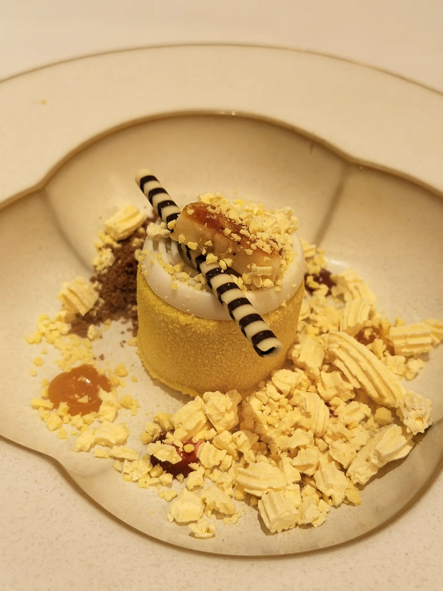 Banana caramel mousse A sweet, tropical crescendo to finish. Silky banana caramel mousse meets a bright mango passion fruit coulis, grounded by a savoury coriander crumble and crowned with playful, airy mango yuzu popcorn.