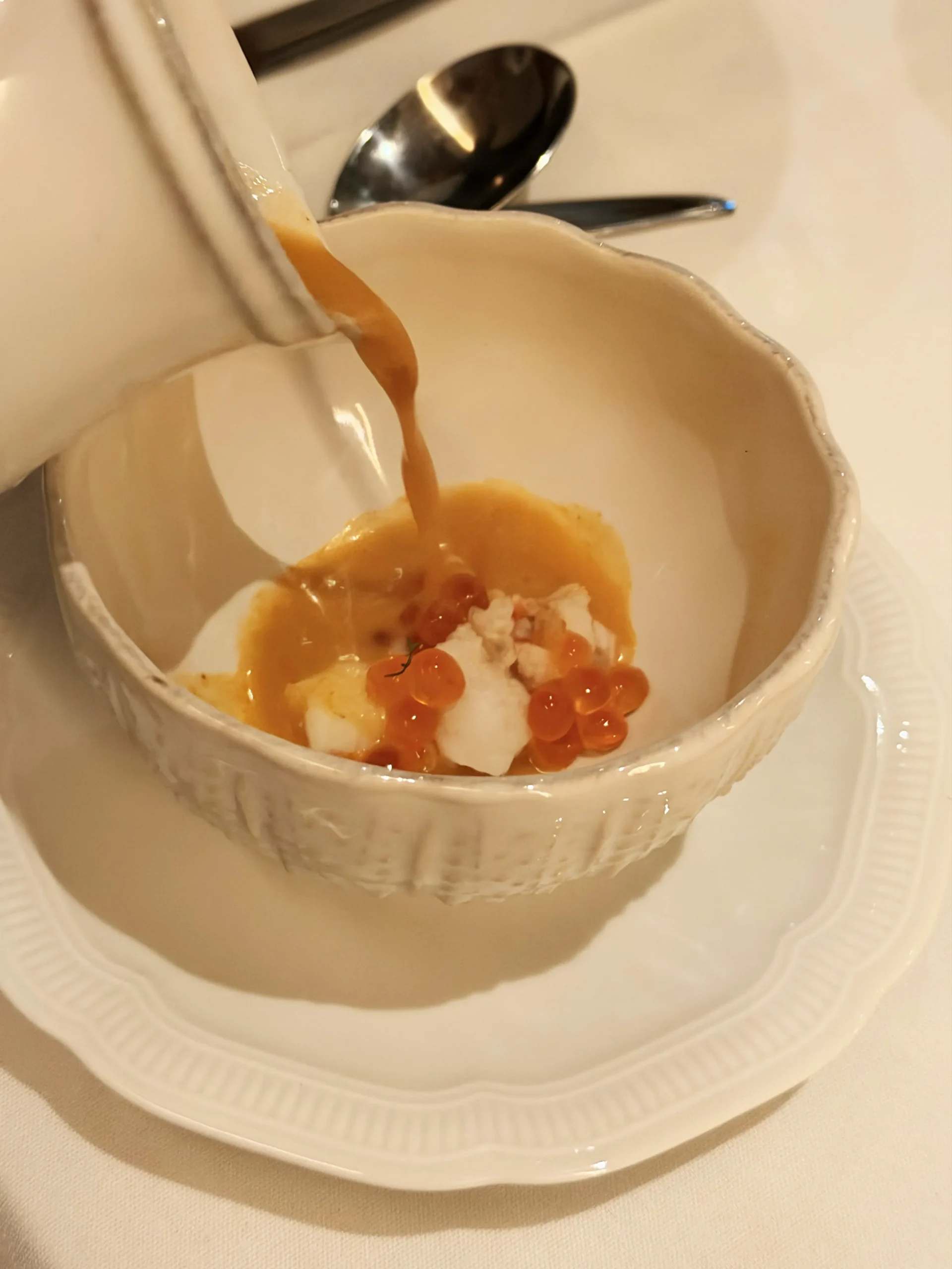 A bowl of fragrant Cochin lobster broth with a mild spice profile and a hint of coconut cream at Quilon London.