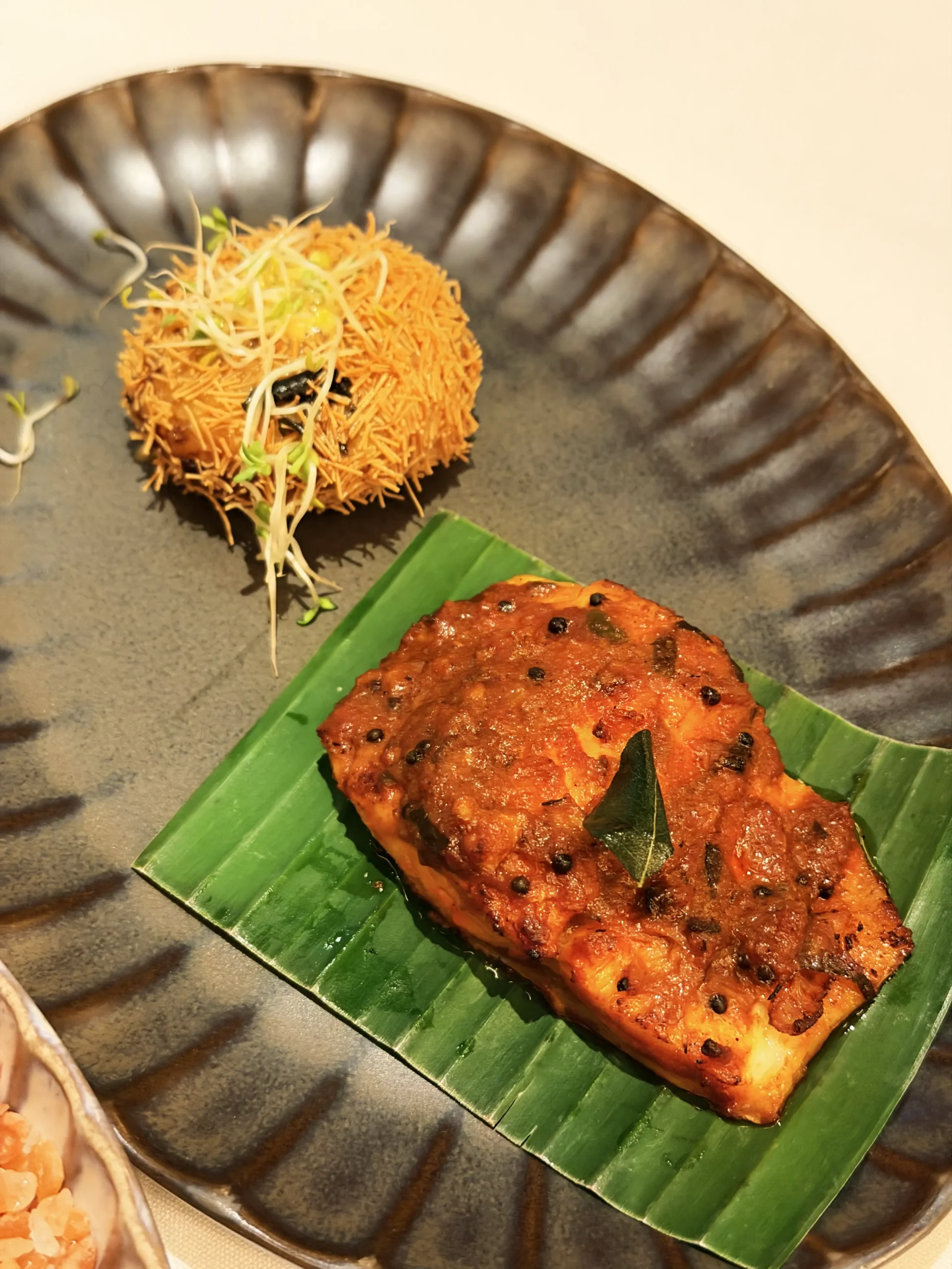 Fresh cold oyster topped with smoked red pepper and heirloom tomato chutney at Quilon London.