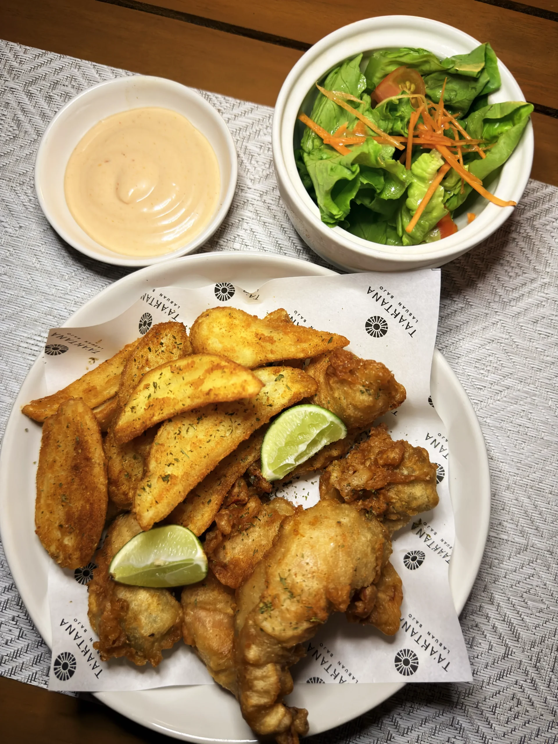 Crispy Gamberoni Fritti featuring golden fried prawns, served with herb-seasoned potato wedges, creamy tartar sauce, and a fresh petite salad at Leros restaurant.