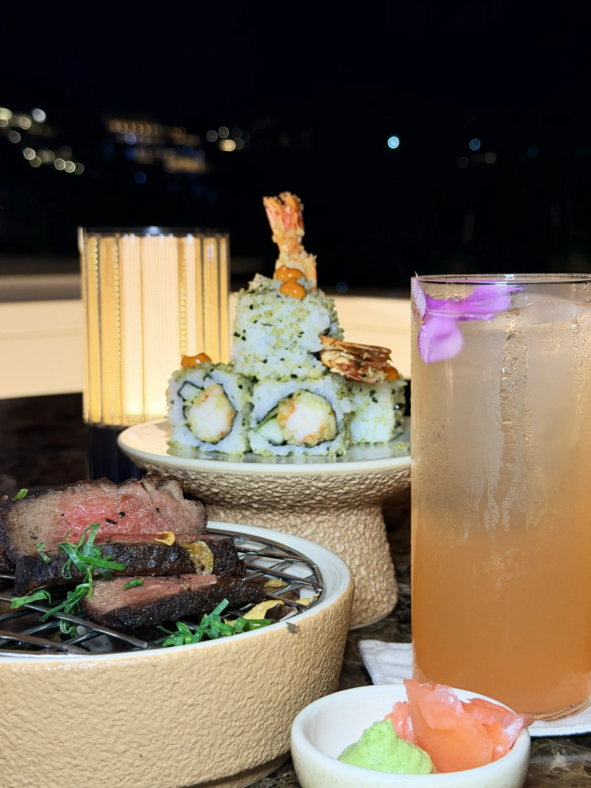 An exquisite fine-dining spread at Ta'aktana, showcasing a curated selection of dishes including Robata-grilled Miyazaki A5 sirloin, Wagyu Tsukune, gourmet tempura rolls, and Mango Kakigori dessert.