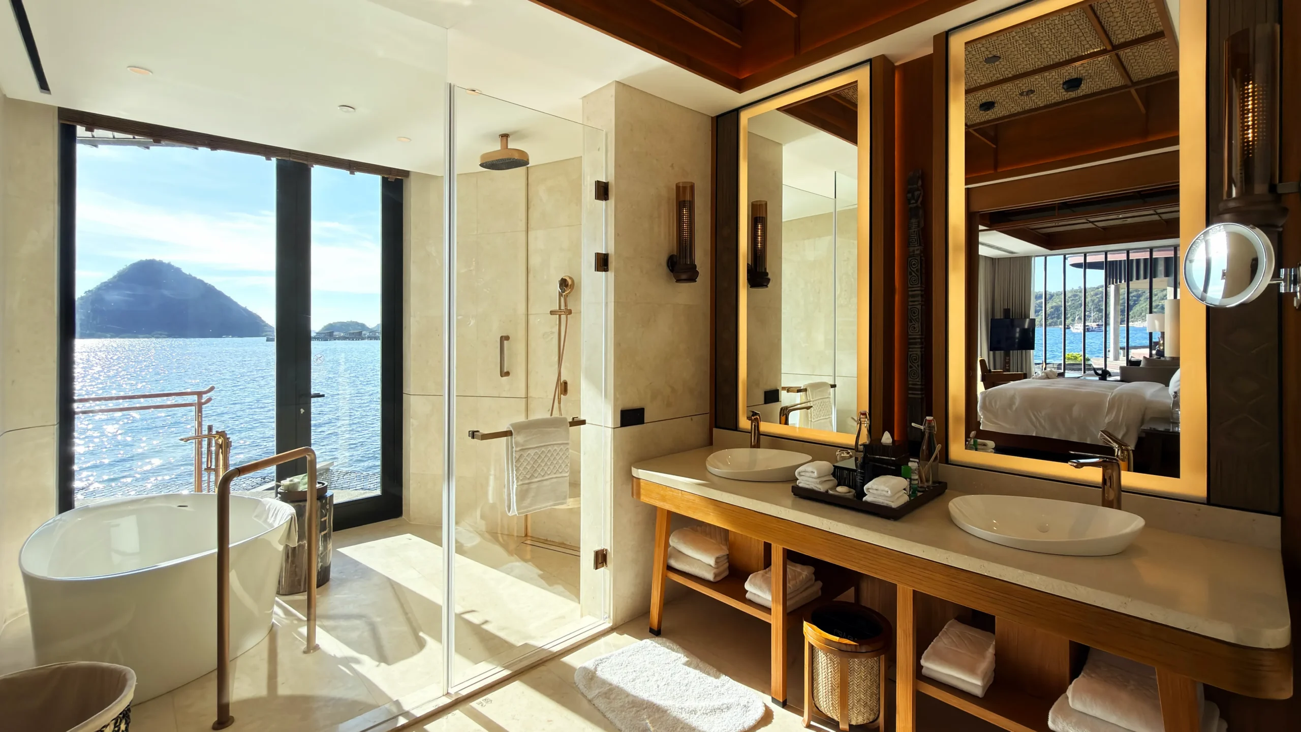 Elegant bathroom inside a Ta'aktana overwater villa, featuring a freestanding deep-soaking tub positioned for uninterrupted views of the open ocean.