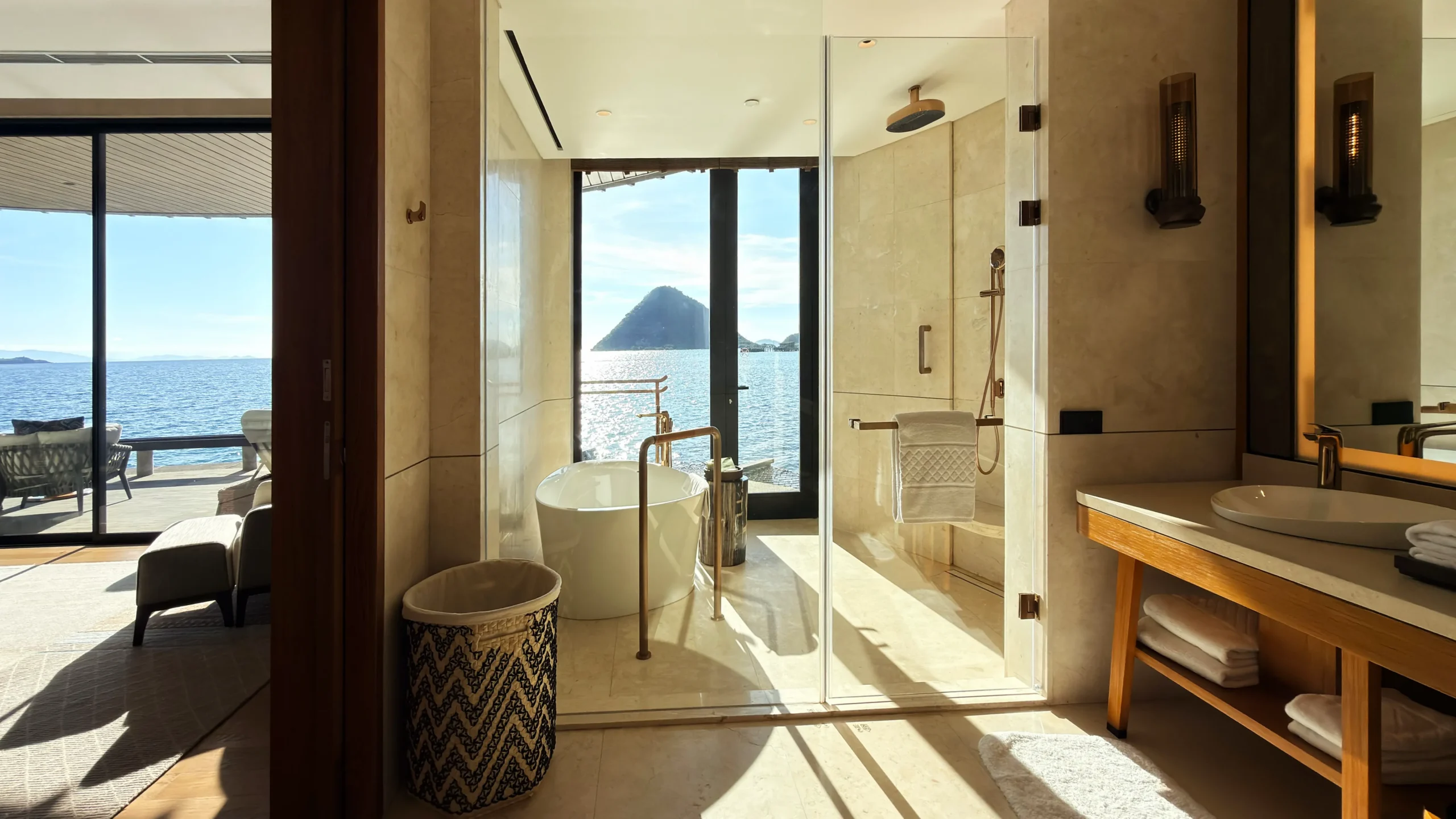 Freestanding deep-soaking bathtub in a Ta'aktana overwater villa with an uninterrupted view of the Indian Ocean.