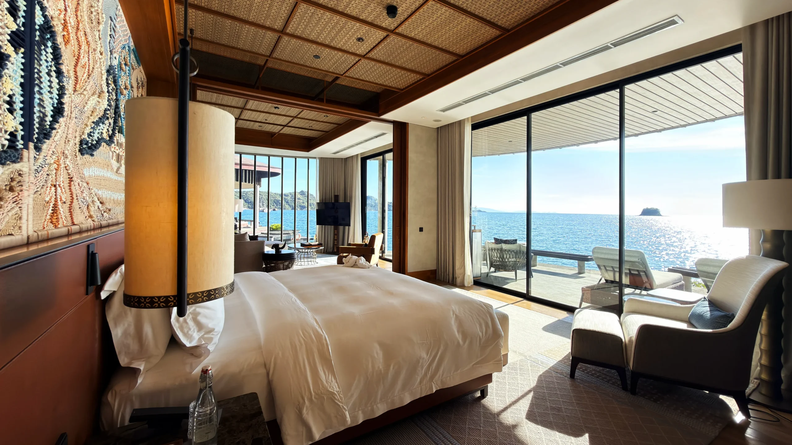 Plush master bedroom suite in a Ta'aktana overwater villa, styled with refined craftsmanship, premium linens, and direct views of the turquoise ocean.