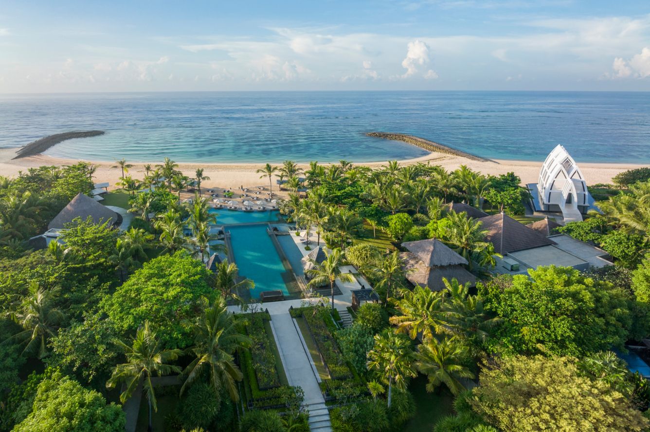 Aerial overview of The Ritz-Carlton, Bali, showcasing the sprawling beachfront resort grounds against the backdrop of the Indian Ocean.