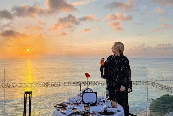 Stefano Malachi taking in the breathtaking golden hour sunset at Jumeirah Bali, framed by the resort's distinctive Hindu-Javanese water palace architecture and the Indian Ocean coastline.
